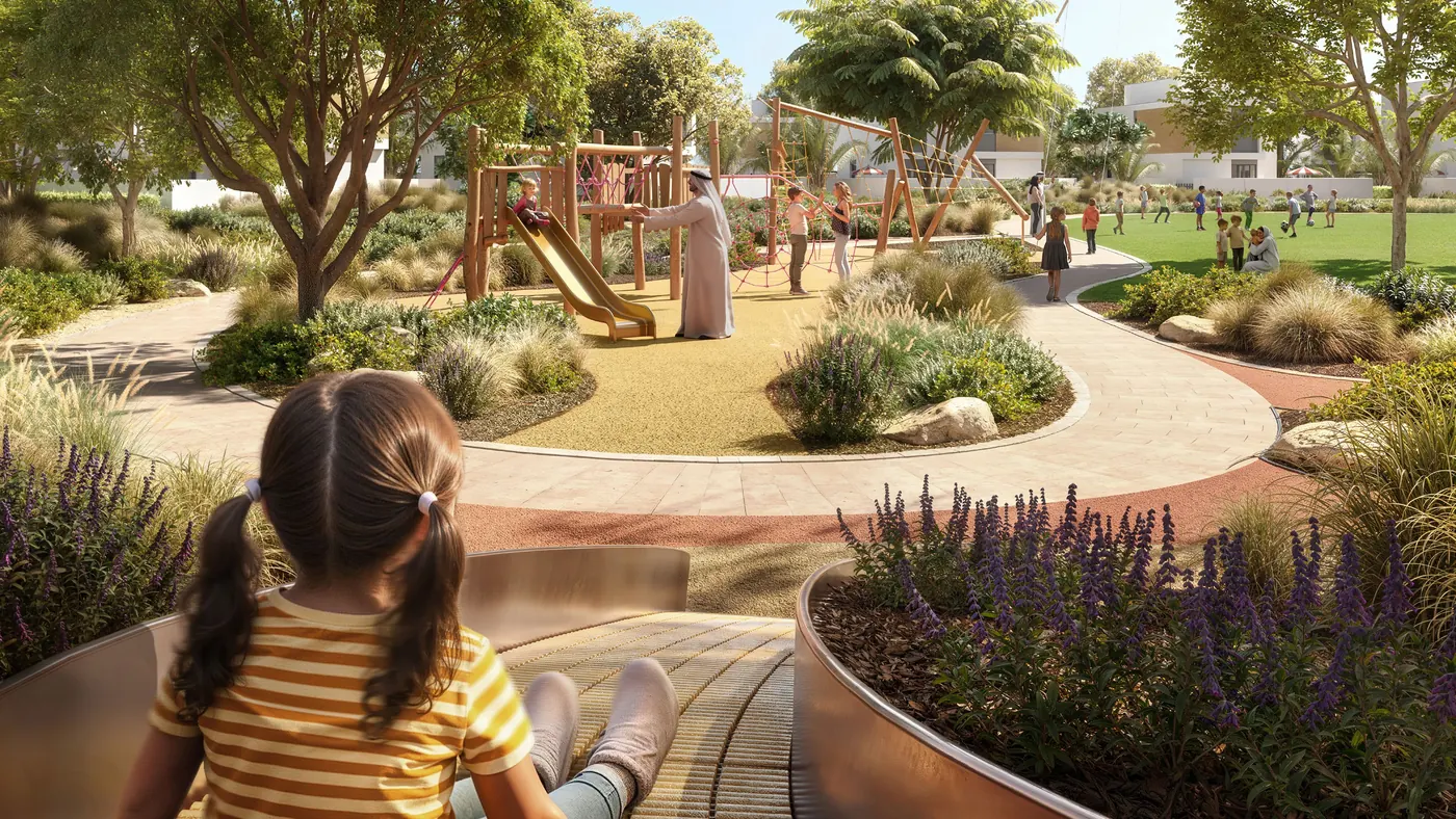 A girl looking out over a landscaped play area with climbing frames